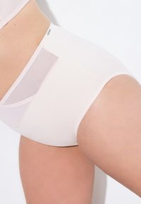 Intimo alto di colore rosa chiaro realizzato in tessuto morbido con pannello laterale in rete trasparente. Presenta un design senza cuciture con cintura elastica.