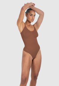 Costume intero marrone con spalline regolabili, design senza cuciture e gambe alte. La texture morbida si adatta a diverse forme del corpo.