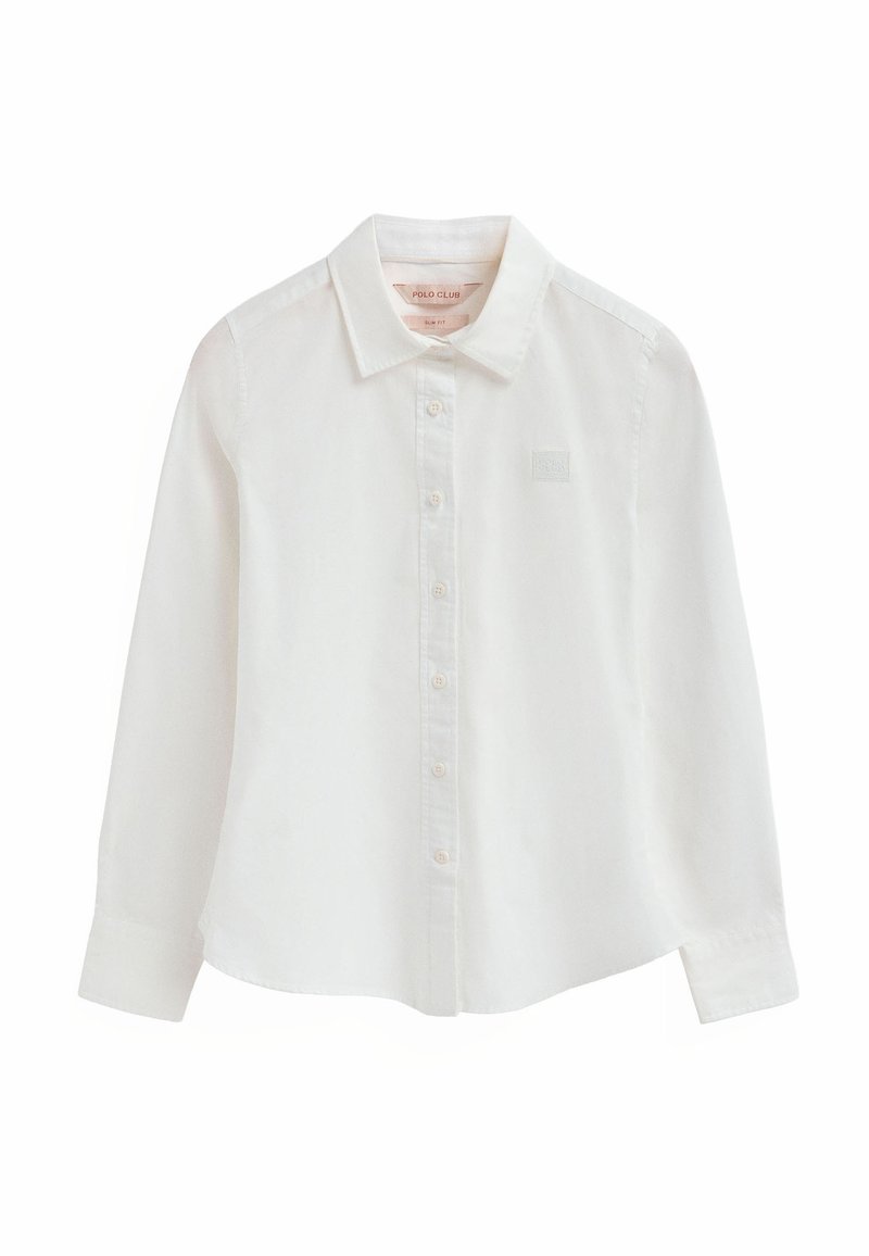 Camisa blanca de manga larga de algodón. Presenta un cuello con punta, cierre frontal de botones y un pequeño logo grabado en el pecho. Textura suave.