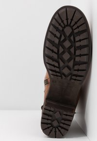 Hnědé kožené kotníkové boty s texturovanou gumovou podešví s cik-cak vzorem a bočním zipem pro snadné obouvání.