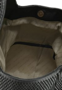 Zwarte geverfde handtas met een gladde binnenkant met een logopatroon. Voorzien van een binnenvak en een drukknoopsluiting voor veiligheid.