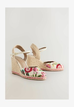 Sandaletter med kilehæle, vævet jutehælg, blomsterbroderet overdel i elfenben og justerbar ankelrem i en lys beige farve.