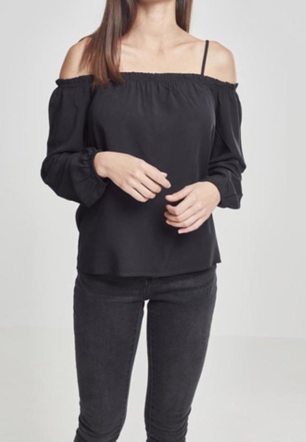 Mustat olkaimeton paita, jossa on joustava kaula-aukko, pitkät hihat joustavilla hihansuilla ja sileä kangas; yhdistetty mustiin kapeisiin farkkuihin.