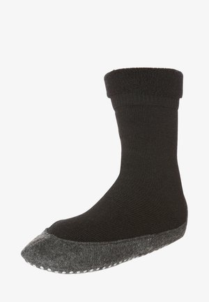 Calzini termici neri con bordo a costine, corpo in maglia liscia e suola in feltro grigia, con accenti bianchi antiscivolo a forma di punto.