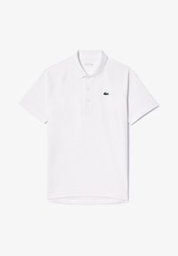 Vit polo-skjorta i mjuk bomull med en klassisk passform, med en tre-knapplåset och en liten grön broderad logotyp på bröstet.