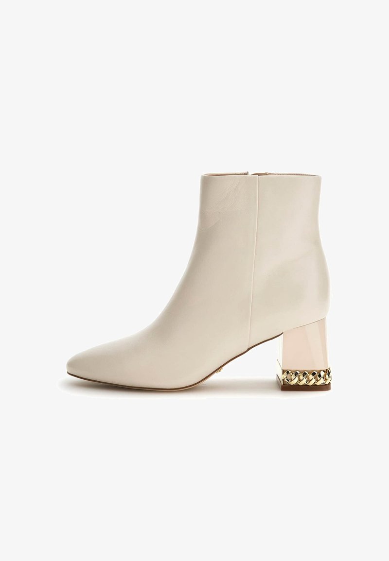 Stivale ankle bianco in pelle con punta appuntita, tacco blocco decorativo in oro e trasparente e superficie liscia. Chiusura a zip sul retro.