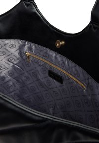 Schwarze Leder-Tragetasche mit glatter Textur. Das Innenfutter hat ein gemustertes graues Futter, eine Reißverschlusstasche und ein markiertes Etikett. Goldene Hardware-Details.
