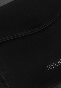 Clutch de cuero negro con una textura suave y bordes cosidos. Presenta la marca en plata "RYŁK" en la esquina inferior derecha.