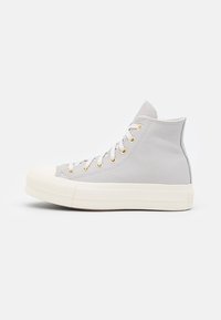 Hoge sneakers van lichtgrijs leder met een witte rubberen neus, beige tussenzool en gouden oogjes voor de veters. Beschikt over een gestructureerd oppervlak.