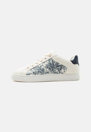 Baskets basses blanches avec panneau latéral floral noir et blanc, œillets dorés, semelle blanche et patch de talon noir, vues de côté droit.