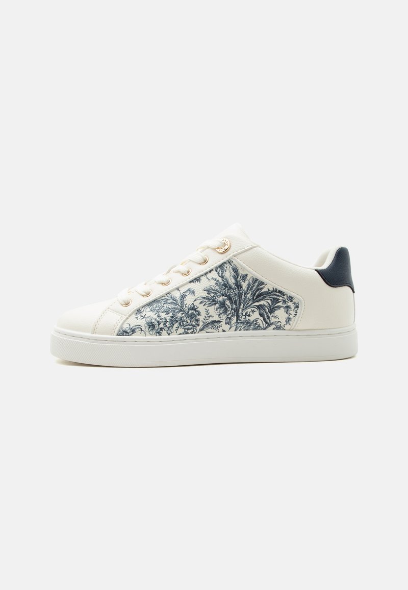 Baskets basses blanches avec panneau latéral floral noir et blanc, œillets dorés, semelle blanche et patch de talon noir, vues de côté droit.