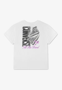 Λευκό T-shirt με γραφικό δύο ψηλών sneakers, μαύρο κείμενο "CONVERSE", μωβ αστέρια και "All Star Brand" σε μωβ γραφή.