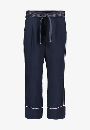 Pantalon court bleu marine avec passepoil blanc sur les côtés et les ourlets, plis à l'avant, passants pour ceinture, et une ceinture assortie en tissu avec coutures blanches.