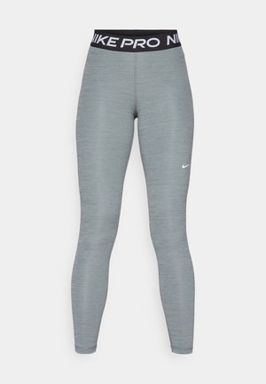 Nike Pro leggings in light gray, featuring a black waistband with white text, smooth fabric, and a slim fit design.