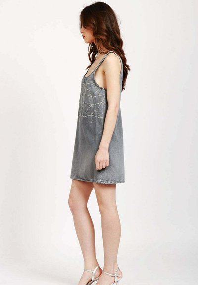Abito in denim grigio sbiadito, senza maniche, con una vestibilità comoda, presenta dettagli ricamati in un motivo geometrico e orlo grezzo.