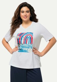 Witte V-hals t-shirt met een kleurrafische afbeelding van gelaagde rode, blauwe en zwarte golven. Korte mouwen en een relaxed fit ontwerp.
