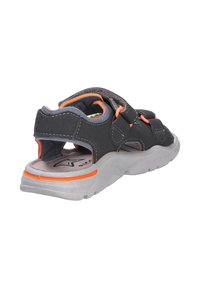 Sandale noire et grise avec des accents orange, dotée de sangles ajustables et d'une semelle texturée pour une meilleure adhérence. Le design ouvert favorise la respirabilité.