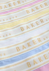 Bandes en tissu de couleurs pastel avec texte en paillettes dorées « BAKER » encadré par deux lignes horizontales en paillettes dorées.