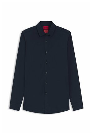 Chemise bleu marine à manches longues avec col, dotée de boutons noirs sur le devant et d'une étiquette de marque discrète en rouge.