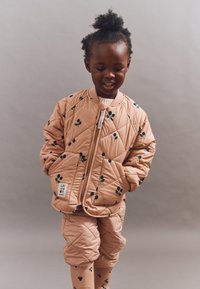 Quilted pink jacket with floral pattern, zip closure, and ribbed collar. Paired with matching pants, both featuring similar designs.