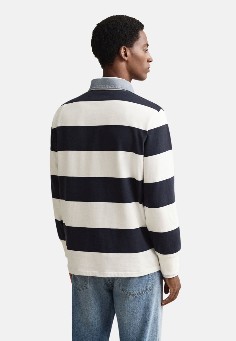 Langärmeliges Poloshirt in marineblauen und weißen horizontalen Streifen. Mit kontrastierendem Denim-Kragen und legerer Passform; aus Baumwollmischung gefertigt.