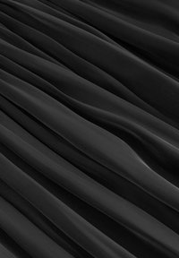 Černá, plisovaná tkanina s jemnou, hladkou texturou a vlnitými liniemi a mírným leskem. Materiál se elegantně skládá ve vodorovných záhybech.