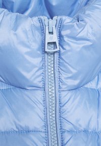 Chaqueta de plumas azul claro con cuello alto, cremallera centrada y textura acolchada. Material de nailon suave con secciones acolchadas.