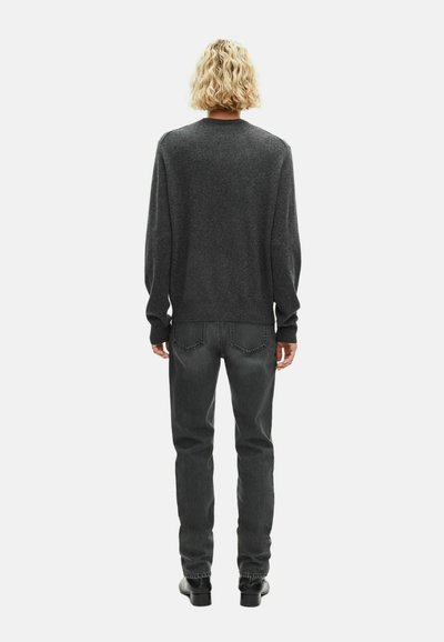 Szary sweter z okrągłym dekoltem i długimi rękawami, zestawiony z ciemnoszarymi dżinsami i czarnymi botkami za kostkę, widok z tyłu na białym tle.