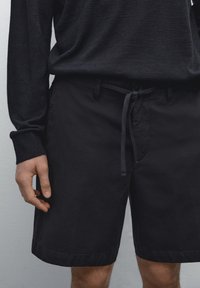 Zwarte shorts gemaakt van een katoenmix, met een trekkoord in de taille, zijzakken en een rechte snit met een omgeslagen zoom.