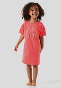 Korallfarbenes Baumwoll-T-Shirt-Kleid mit kurzen Ärmeln, das ein Friedenssymbol-Design zeigt, umgeben von floralen Elementen in lebendigen Farben.