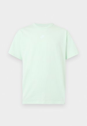 Lys grøn Nike T-shirt med korte ærmer, rund hals og lille hvidt logo centreret på brystet mod en ensfarvet baggrund.