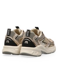 Beige en zwarte mesh sneakers met een ergonomisch ontwerp, een gewatteerde zool en een achterste treklus met branding op de hak en de tong.