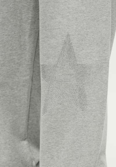 Γκρι φούτερ με υφή και διακοσμημένο με αστέρια από στρας στο μανίκι. Μαλακό ύφασμα με άνετη εφαρμογή.