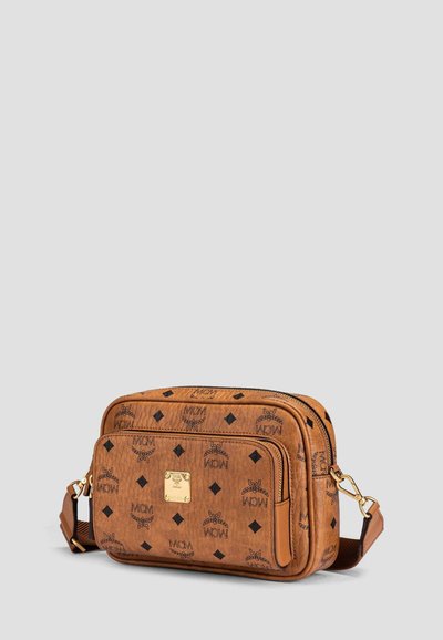 Brown leather crossbody bag with black logo print, two zippered compartments, gold metal logo plate, and adjustable shoulder strap.