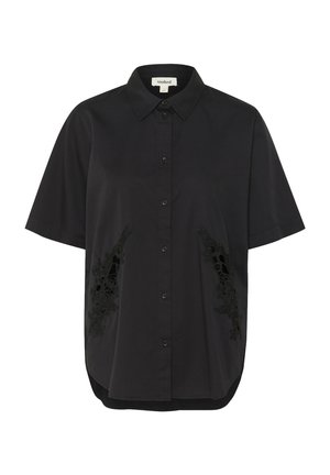 Svart kortärmad skjorta med knäppning framtill, med intrikata svarta broderade detaljer på båda sidor och en rundad nederkant.
