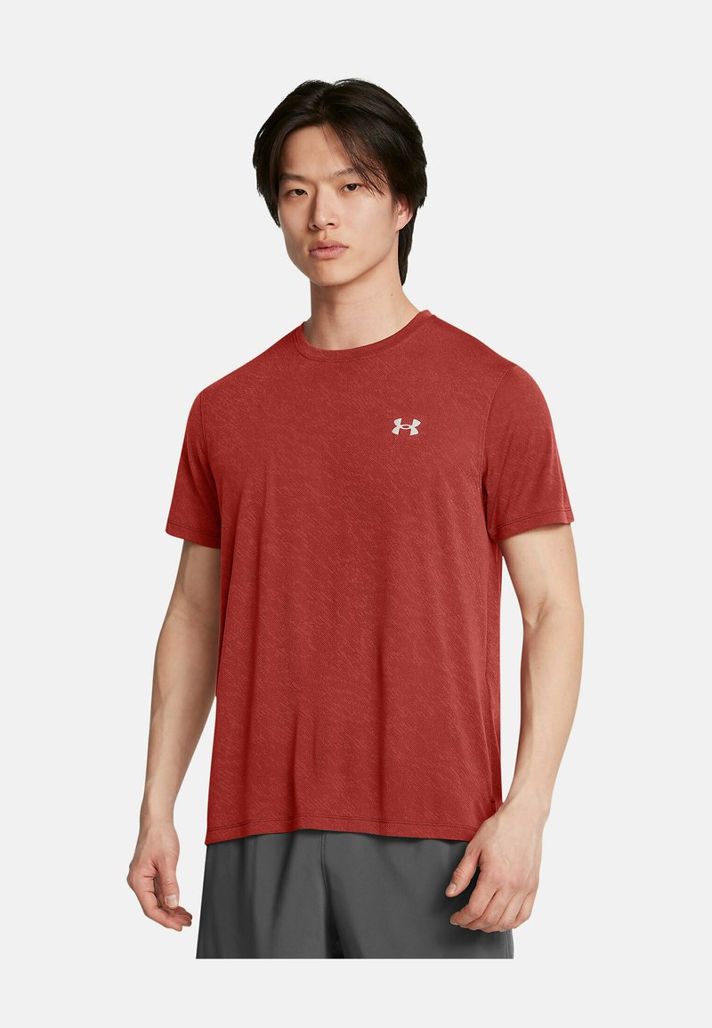 Camiseta atlética roja de manga corta con cuello redondo y textura ligera. Presenta un pequeño logo blanco en la parte superior izquierda del pecho.