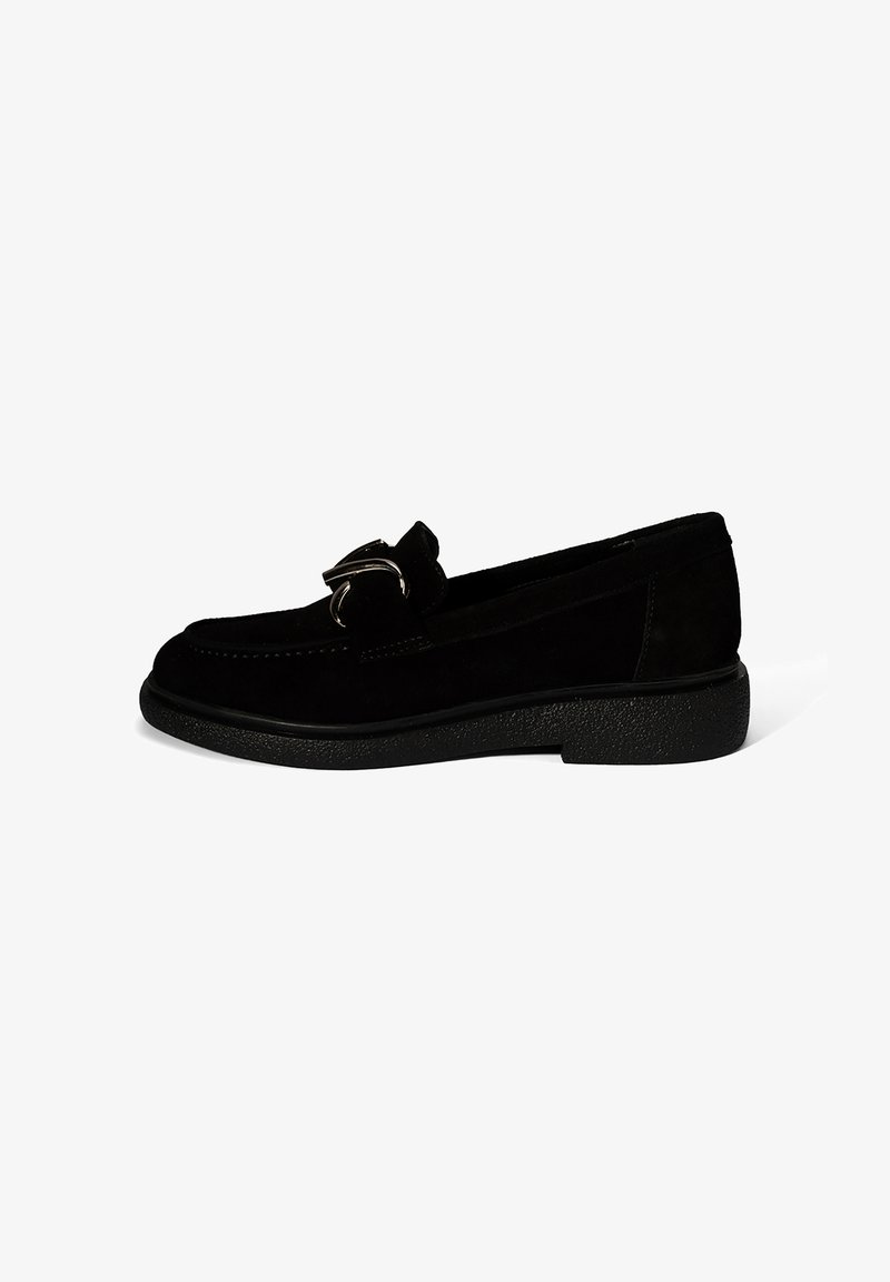 Mocassins en suède noir avec un bout rond, accent en métal argenté et semelle synthétique texturée noire. Fini lisse avec une subtile brillance.