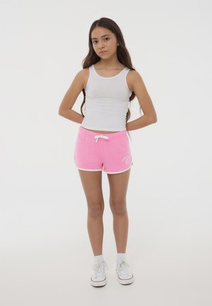 Shorts di cotone rosa con bordo bianco e cordoncino regolabile, abbinati a una canottiera bianca. Design semplice senza motivi o grafiche.