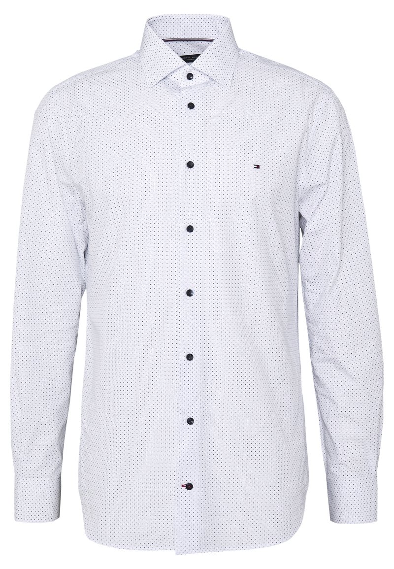 Camicia bianca con bottoni, decorata con piccoli pois neri, maniche lunghe, colletto classico e bottoni scuri. Presenta un accento con logo discreto. Texture liscia.