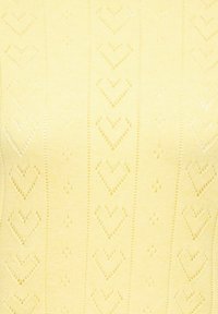 Tissu tricoté jaune avec des rangées verticales de motifs en forme de cœur et de losange en trou-trou.