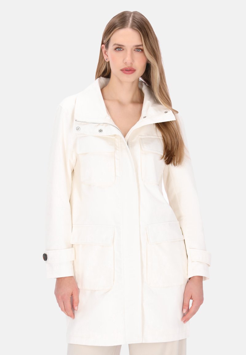 Hvid letvægtsjakke med høj krave, lynlås foran, to store brystlommer og knapremme på ærmerne. Glat tekstur.