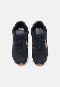 Sneaker in suede nero con un accento in stampa leopardata sui lati, con lacci neri e una suola in gomma che presenta un motivo a onde.