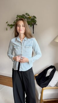Hele sinine teksasärk, millel on nööbistatud esiosa, kaks rinna-taskut ja pikad varrukad. Kanda mustade laia säärega pükstega.