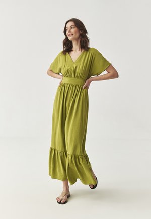 Green, long dress with a V-neck, short sleeves, and an elastic waist. It features a tiered ruffled hem and a soft, lightweight texture.