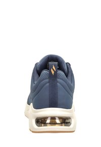 Blaue Turnschuhe mit gepolstertem Kragen und Zunge, ausgestattet mit einer klaren Luftpolstereinheit, weißer Zwischensohle und strukturierten Akzenten im Obermaterial.