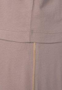 Light mauve fabric with a smooth texture. Features a seam and a gold accent stripe running vertically along one side.