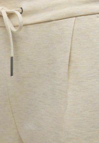 Lichtbeige joggers gemaakt van zachte stof, met een verstelbare trekkoord taille en een zijzak met een lichte textuur.