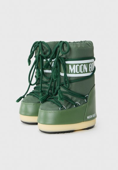 Zielone śniegowce o błyszczącej powierzchni, z wyściełanym wierzchem, związane sznurówki oraz biała taśma "MOON BOOT". Gumowa podeszwa dla lepszej przyczepności.