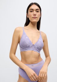 Μπραλέτα από λιλά δαντέλα με τριγωνικό σχήμα, λεπτές ρυθμιζόμενες τιράντες, κυματιστά άκρα και διακοσμητικό φιόγκο στο κέντρο.