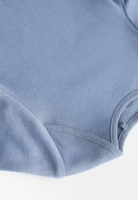 Niebieski bawełniany body, krótkie rękawy, o gładkiej fakturze, z okrągłym dekoltem i zatrzaskami u dołu ułatwiającymi zakładanie.